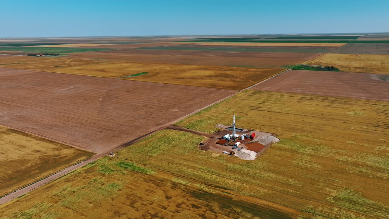 Immense plantation divided into the fields. Flying closer to the site for drilling oil, gas or shale gas.