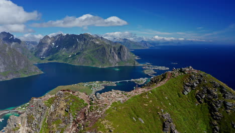 aerial drone shot over reinebringen, reine, lofoten islands, norway.
high view of the picturesque green landscape. view of the fjords and blue nordic sea. touristic attraction for hiking activities.