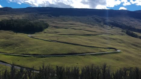 Cars-driving-up-and-down-a-curvy-road-on-Haleakala-a-volcano-on-the-island-of-Maui-Hawaii-near-sunrise,-January-2019