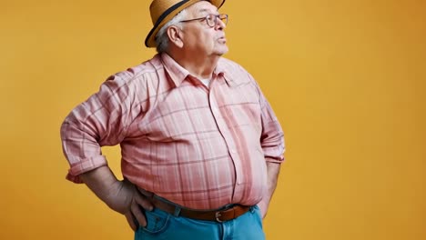 a man in a hat and glasses standing with his hands on his hips