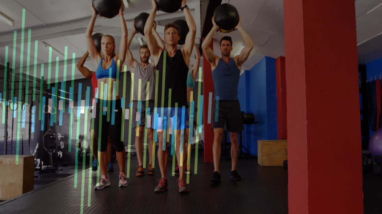 Overhead medicijnbal lunges uitvoeren tijdens een begeleide les, groep beweegt voorwaarts in de sportschool in sportkleding.
