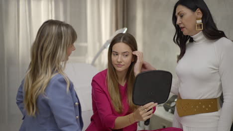women in beauty salon consultation examining results