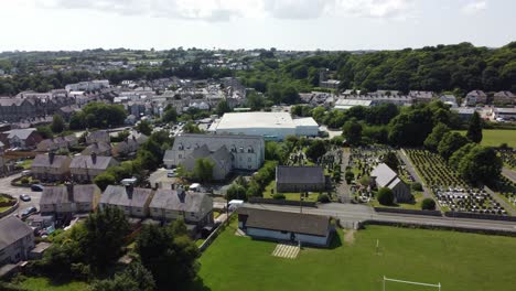 Welsh-Llangefni-village-aerial-view-looking-down-over-sunny-small-town-council-house-rooftops-and-idyllic-gardens