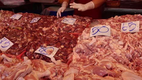 person organizing various chicken parts on display