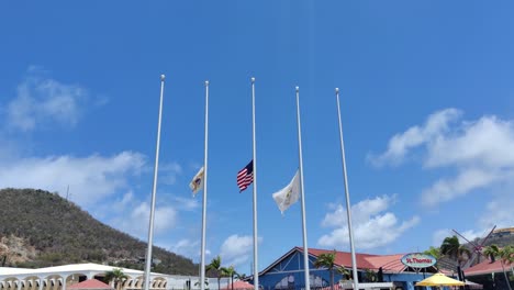 flag of usa virgin island and usa half mast waving to honor the victims of the tragedy | st thomas virgin island and usa flags waving on port in charlotte amalie, u