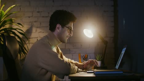 hombre trabajando tarde en la noche en la computadora portátil