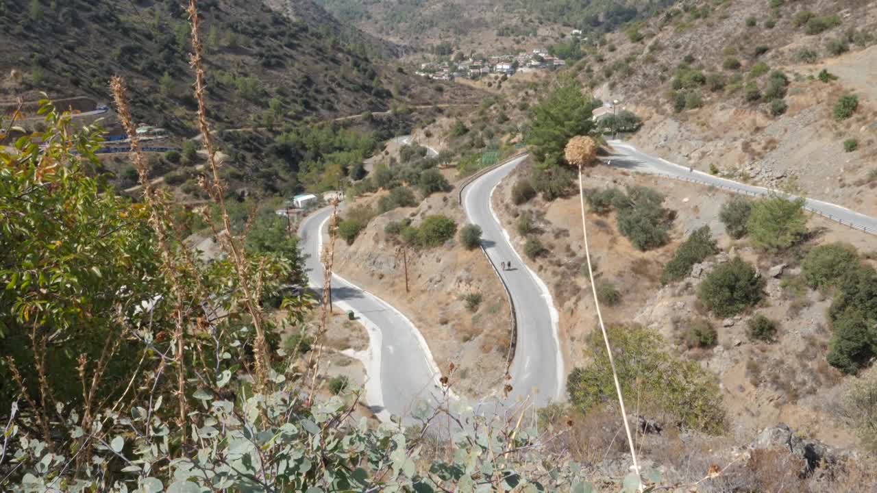 휘어지는 산길에서 하이킹하는 두 소녀를 내려다보고 있습니다.