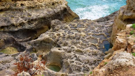 rocky coast with tide pools, shaped by erosion with rugged, weathered rocks and unique formations in algarve, portugal. - static shot