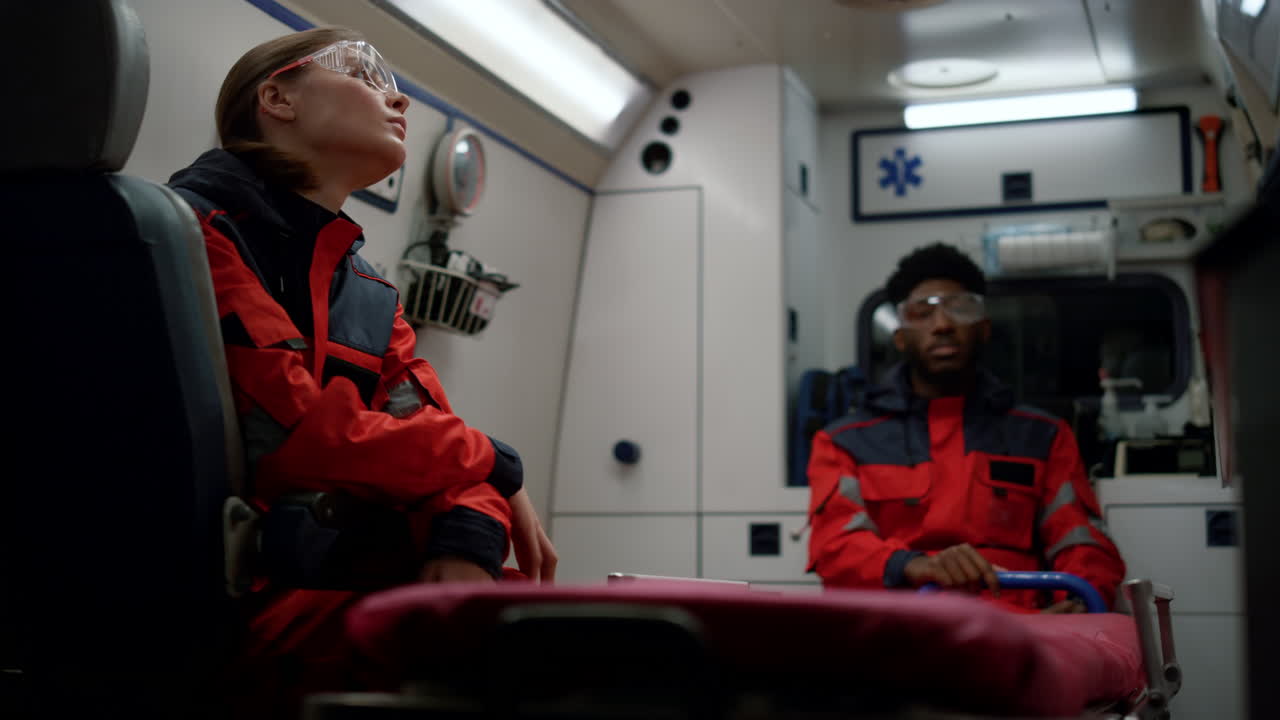 измученные работники скорой помощи сидят в аварийном автомобиле