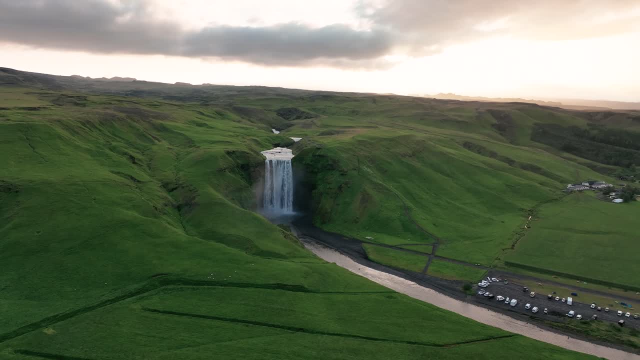 skogafoss, en el sur de islandia - dando vueltas alrededor de la cascada en pleno verano - toma aérea de un dron