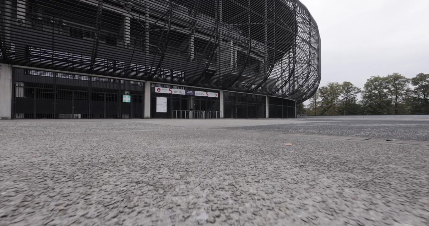 Tomada dinâmica de gimbal de um estádio de futebol moderno na Europa Central em um dia de verão nublado, 4K