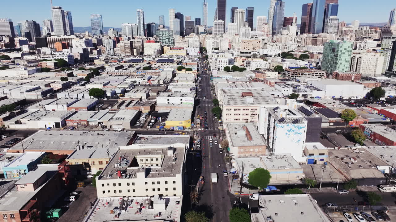 Aerial View of a Bustling City Street with Diverse Buildings and Distant Skyline