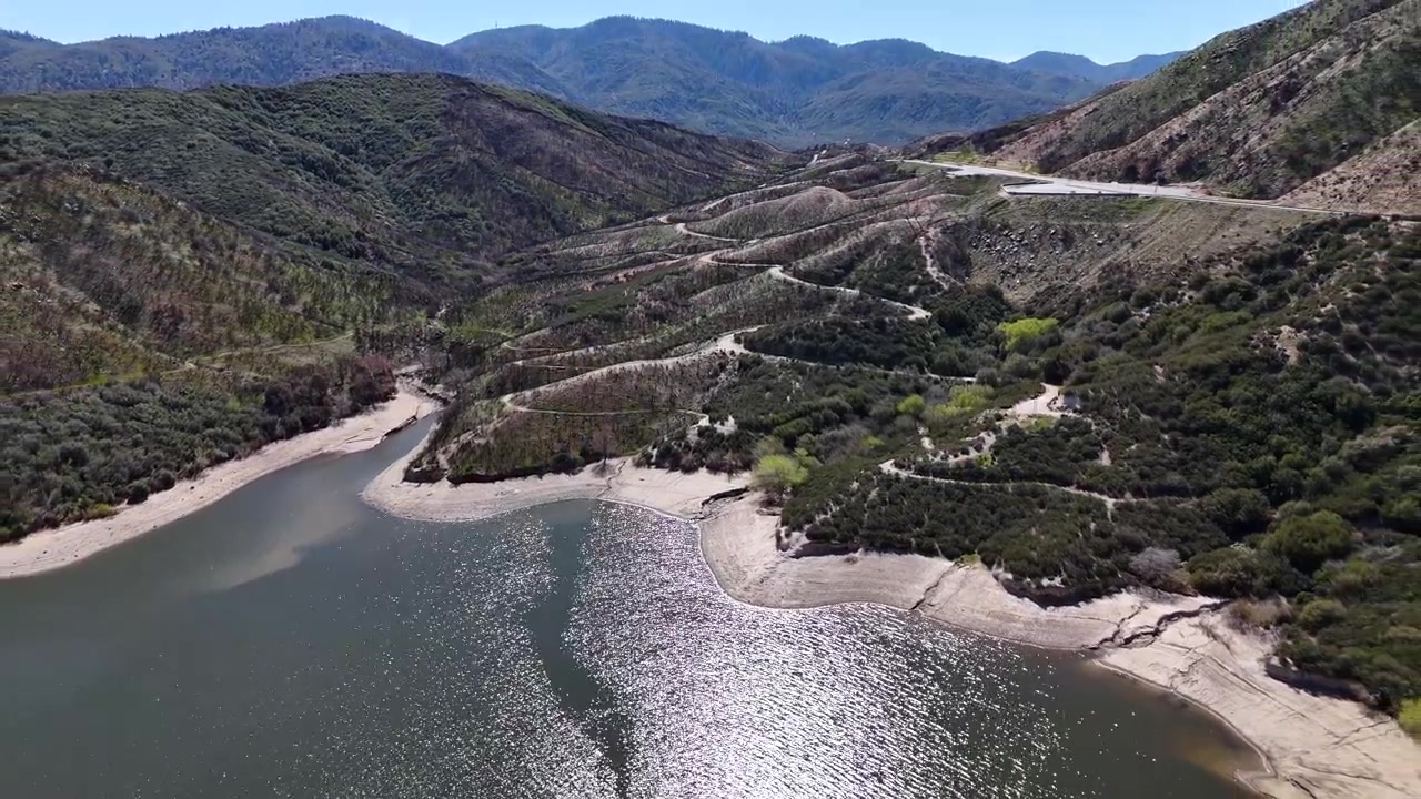 Ripresa drone del Lago Silverwood in California, USA, costa del bacino idrico e strade collinari