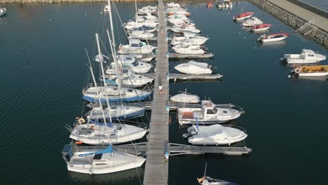 two people walking towards the port of yacht club at rianxo in a coruña, spain