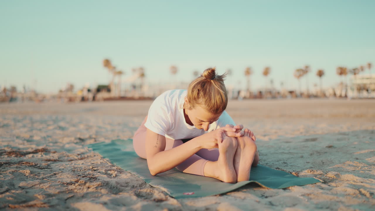 una mujer en forma haciendo ejercicios de yoga al aire libre.