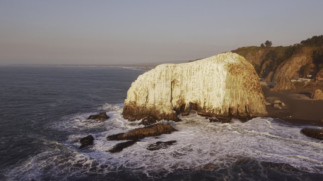 Cinematic tracking shot following the powerful surf as it hits the rocky headlands near Constitucion