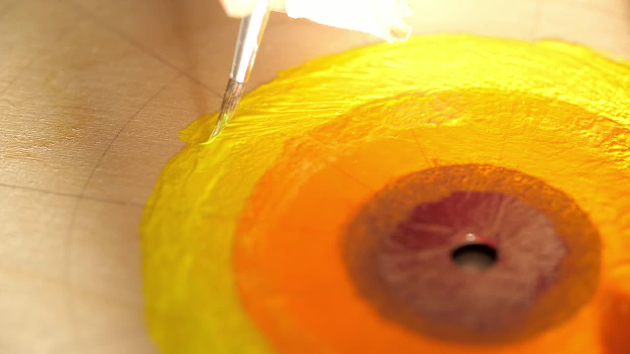 Painting a Circular Design with Yellow and Orange Paint on Wood