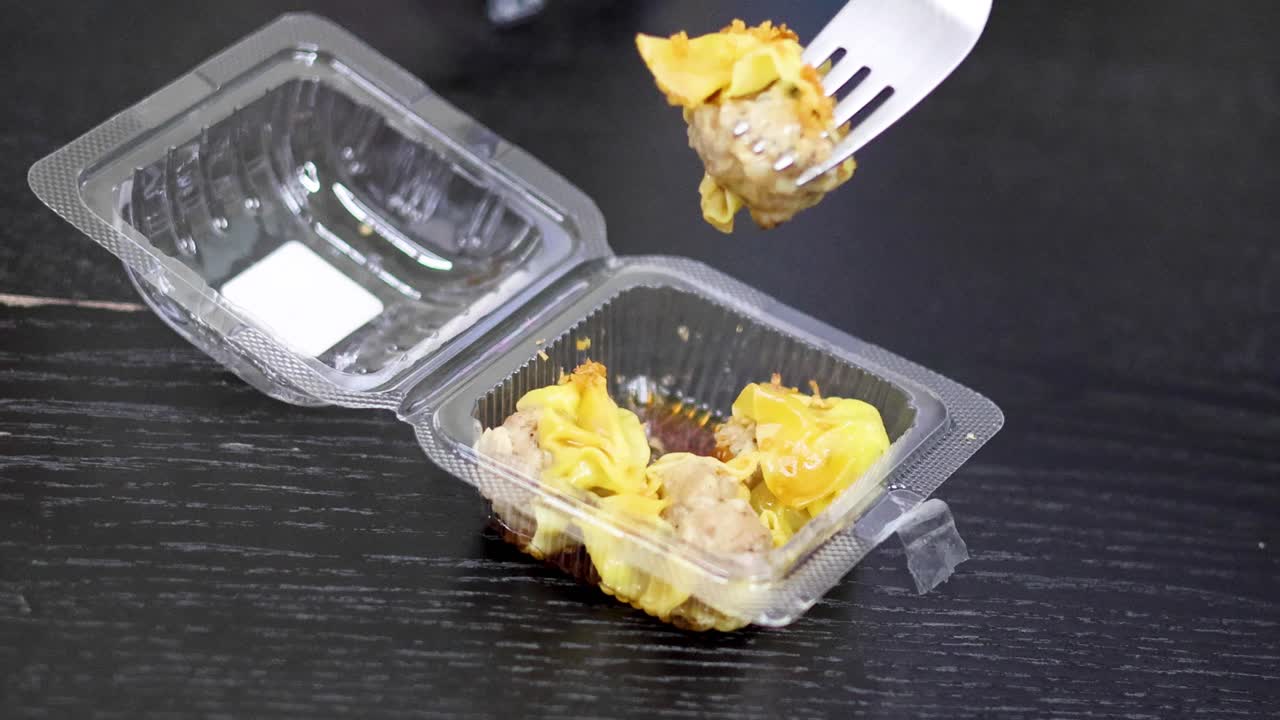 elevar el bollito con el tenedor de un recipiente de plástico