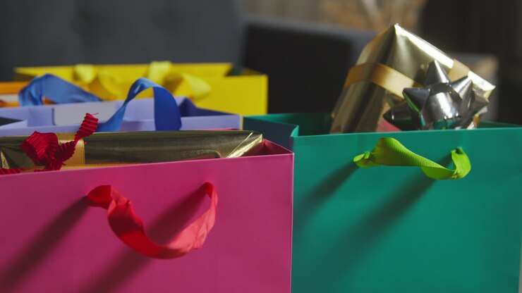 Close Up Of Gift Wrapped Presents In Colourful Bags With Tag On Table In Lounge At Home