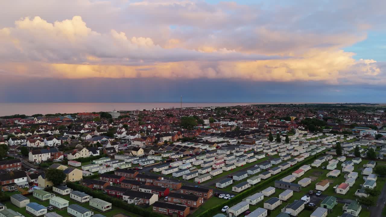 Coastal panorama of the town of Skegness with looming storm clouds over the North Sea. Seaside scene with rooftops at sunset
