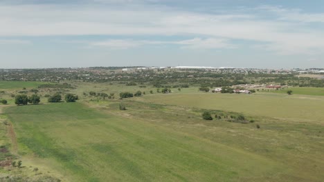 Drone-aerial-footage-over-farmlands-towards-city