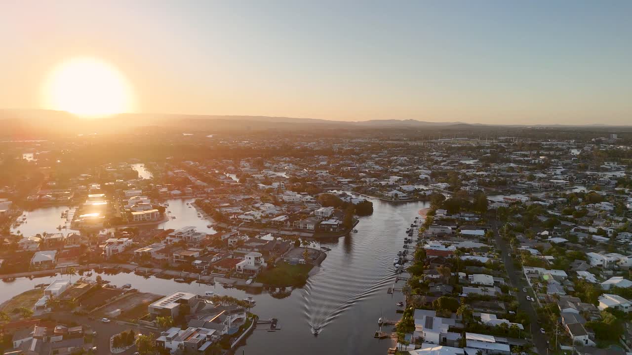 Aerial view of Gold Coast's Nerang River at sunset, showcasing vibrant colors and serene waterways captured in a smooth hyperlapse