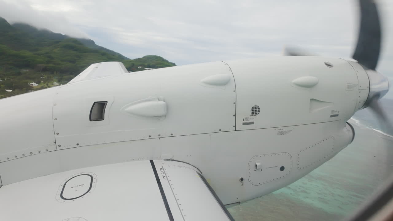 Inside airplane looking out at wing and propellor as plane descends