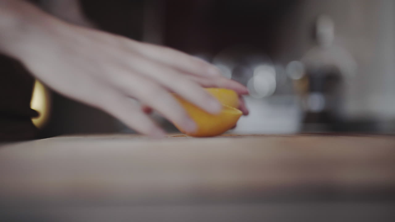 Affettatura rapida di una succosa scorza d'arancia in cucina, in primo piano.