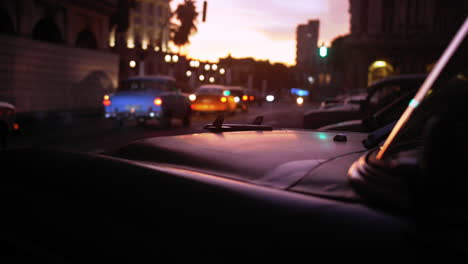 dramatic cinematic sunset clip on the streets of havana as the sun goes down and rows of vintage taxis drive past.
