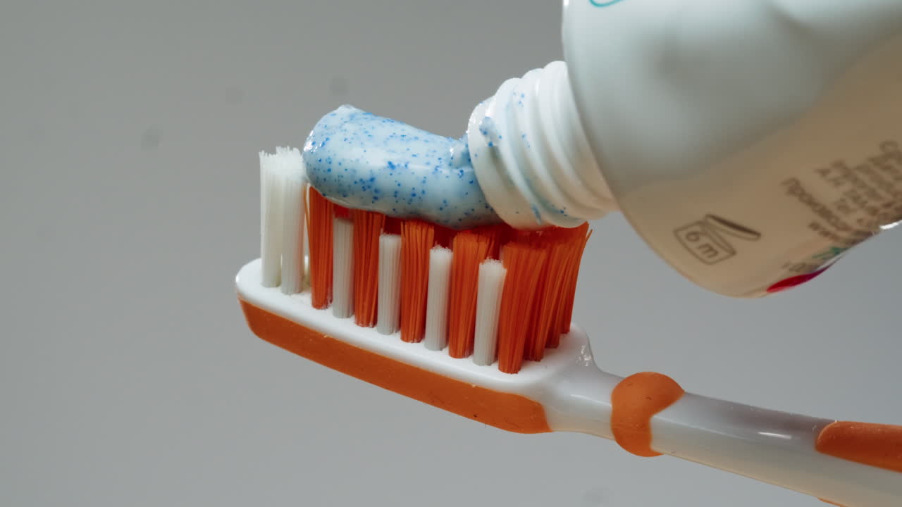 Applying toothpaste to toothbrush