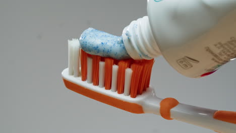 applying toothpaste to toothbrush