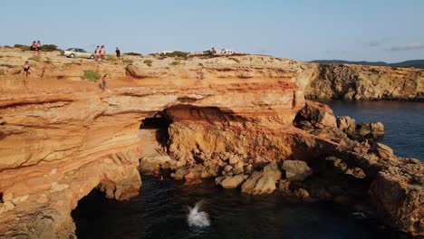 male cliff diving at sa figuera borda at ibiza during sunset