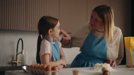 woman-is-teaching-her-little-daughter-to-make-dough-for-pizza-or-pie-mother-is-kneading-flour-on-table