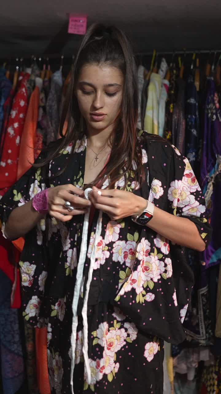 mujer intentando un kimono floral en una tienda de ropa