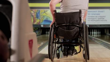 two young disabled men in wheelchairs playing bowling in the club