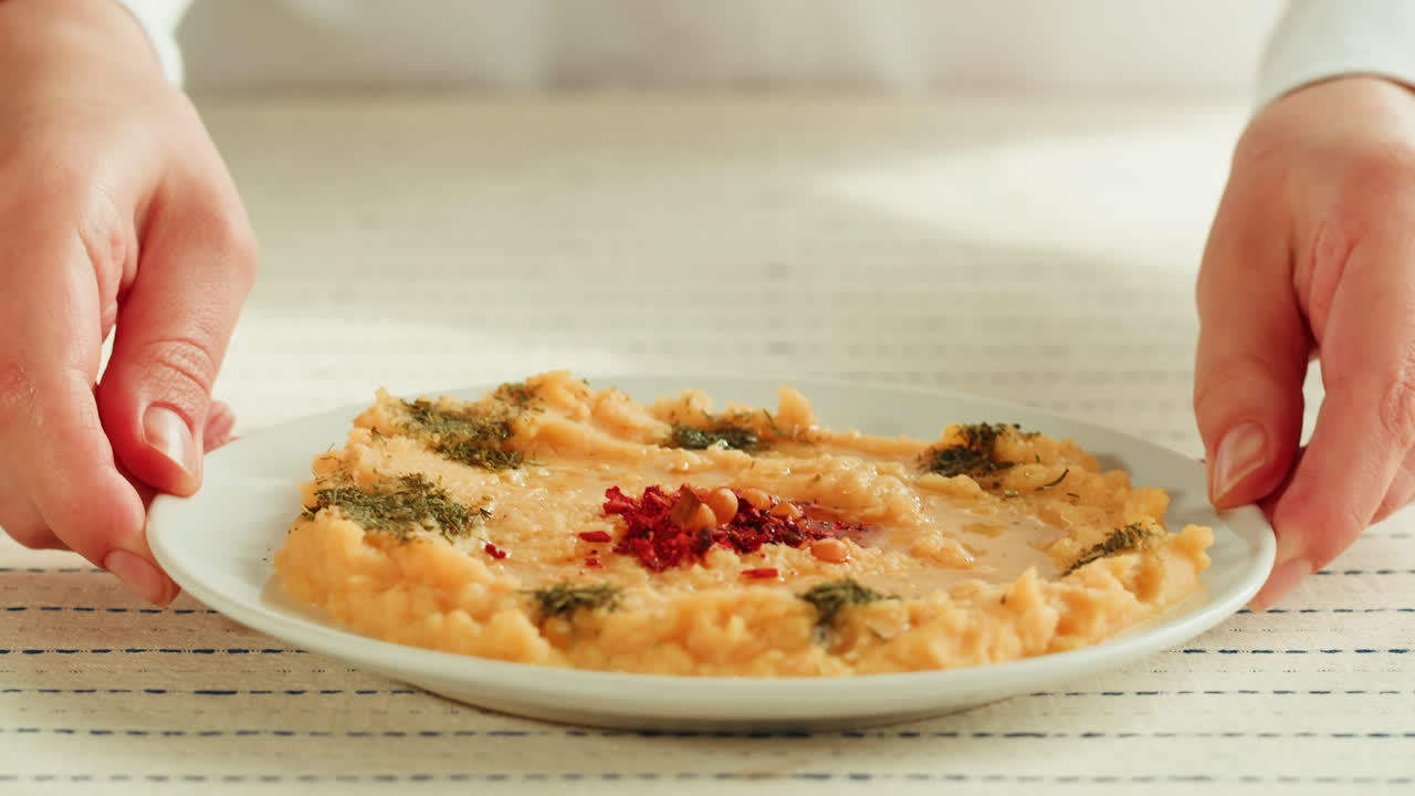 Donna che Serve un Piatto di Purè di Ceci