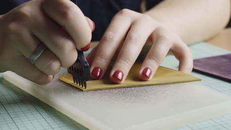 close-up of a woman crafting with leather on a handmade project