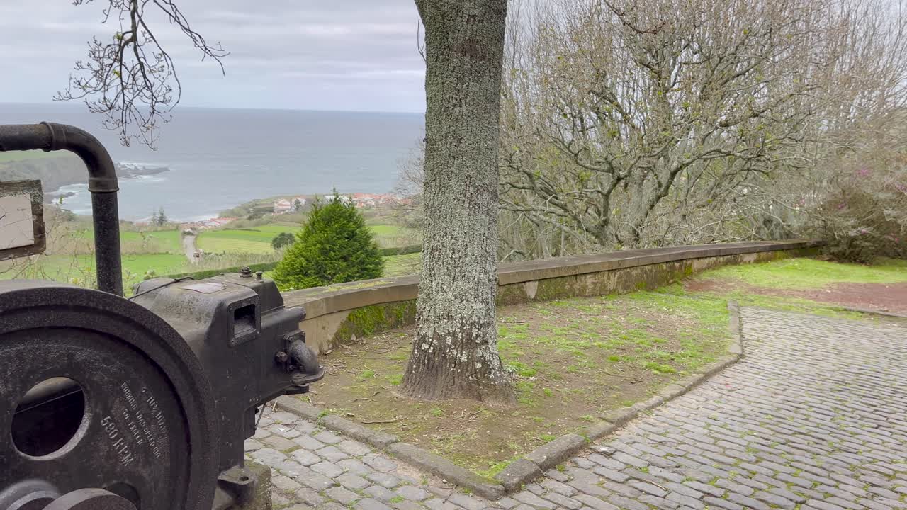 View of the Azores seaside with an old tea factory sign and cobblestone path leading to a stunning ocean landscape. Captures cultural and historical significance, blending natural beauty and heritage.