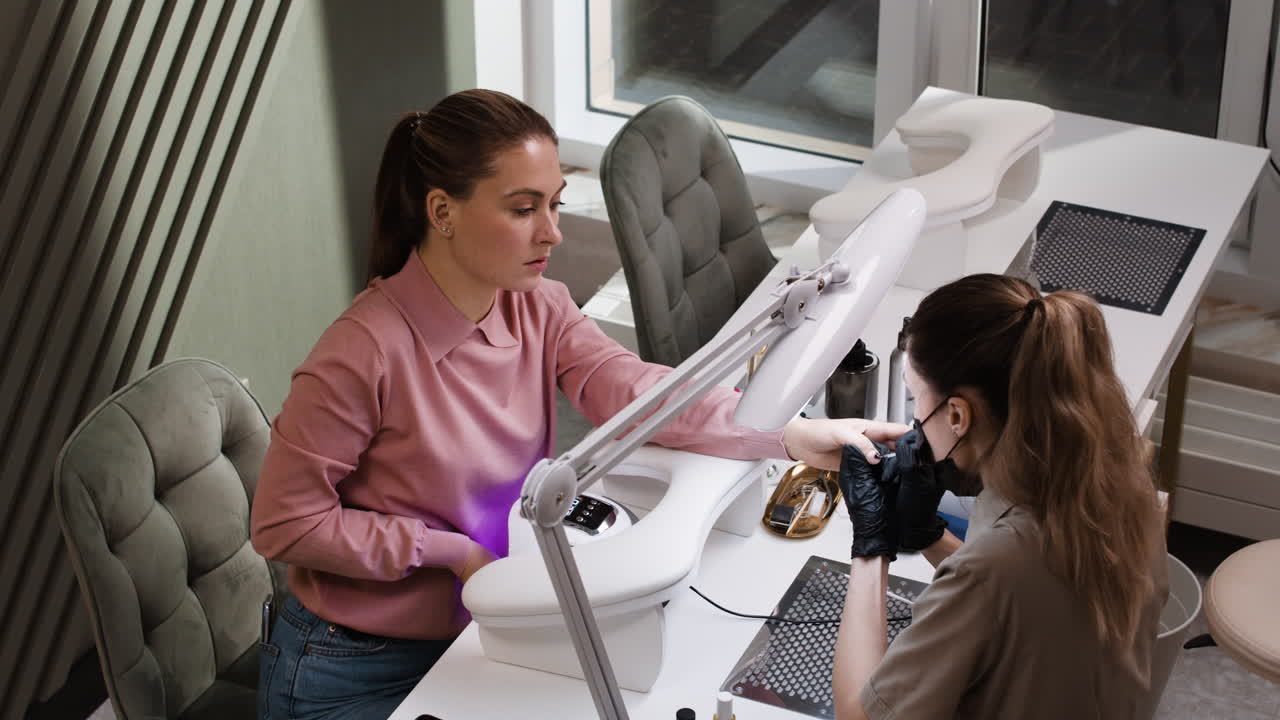 una mujer haciendo una manicura en un salón de uñas.
