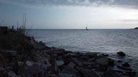 time lapse of a barren, rocky shoreline and fast moving clouds over turbulent water