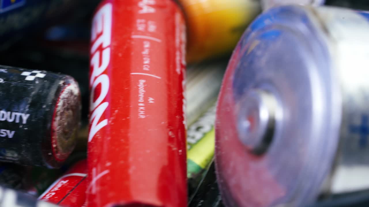 Multiple used Varta AA alkaline batteries are seen arranged in a pile. Hazardous waste concept