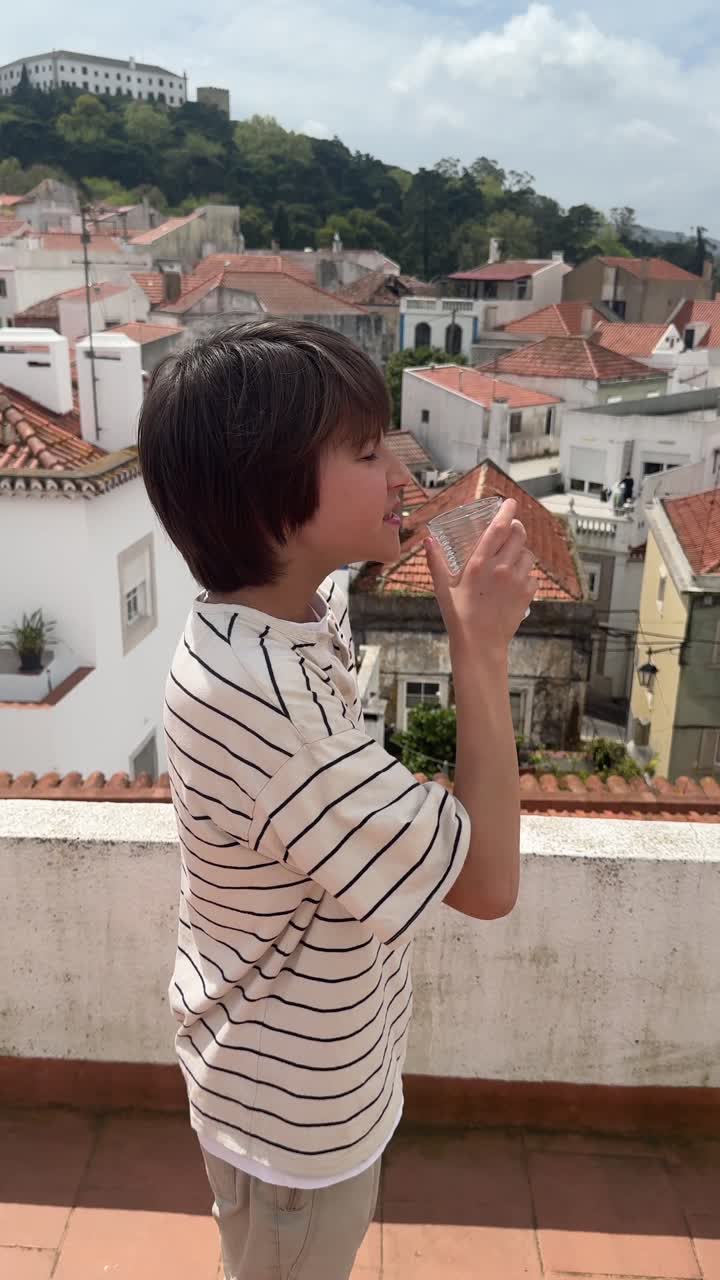 Boy Drinking Water on a Rooftop in Portugal