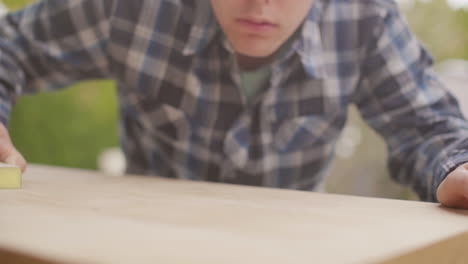 man sanding a wooden table