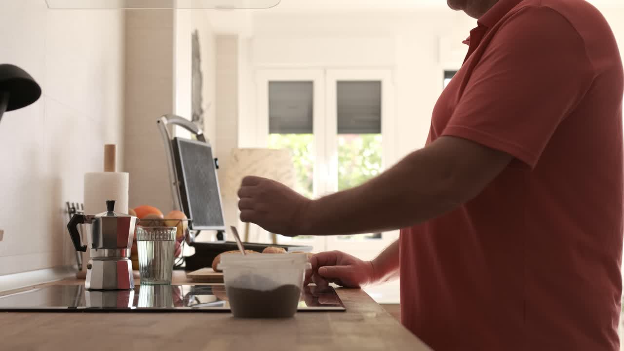 Uomo che prepara il caffè a casa al mattino