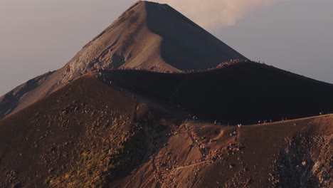 Toma-Aérea-De-Teleobjetivo-De-Personas-Observando-Un-Volcán-Activo,-Puesta-De-Sol-En-Guatemala