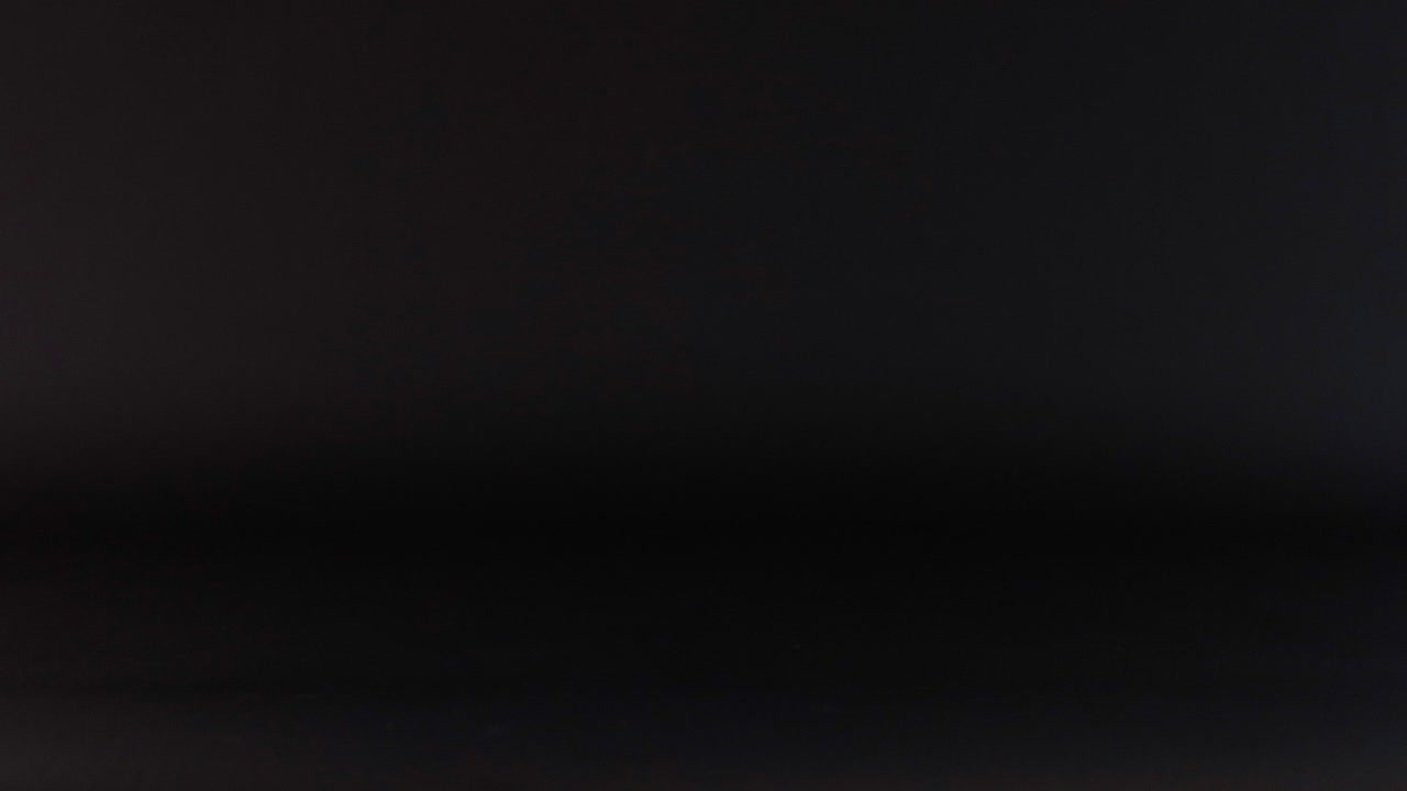 A blue tennis ball bounces in darkness