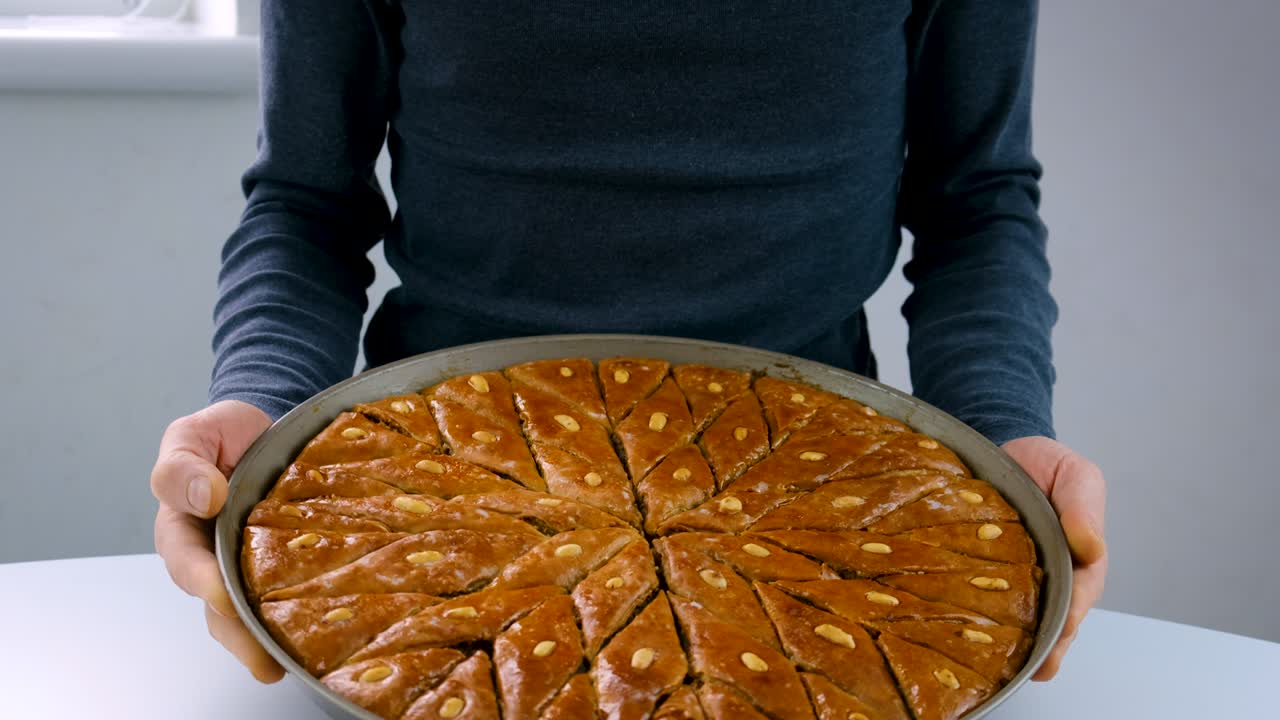 En mand holder baklava. Selektivt fokus. Mad.
