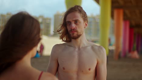 a man seems shocked to see a woman who has been harmed on the beach - close up