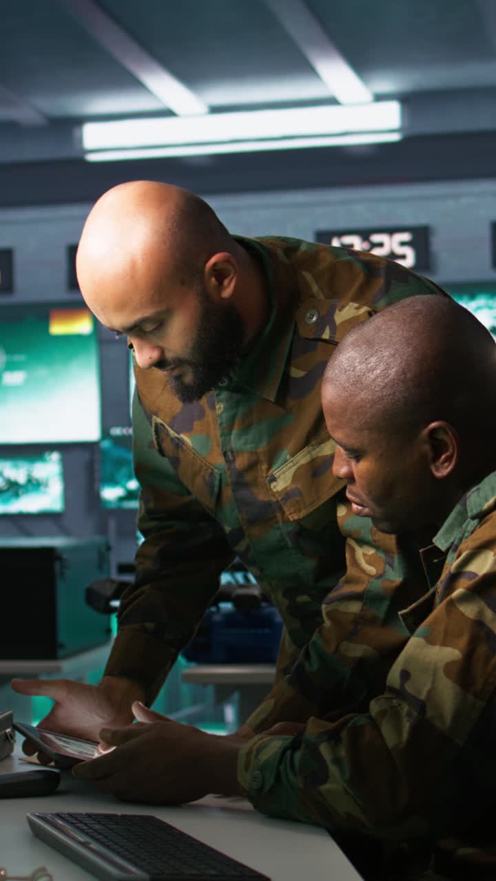 Vertical video Military dispatcher helped by coworker with tablet