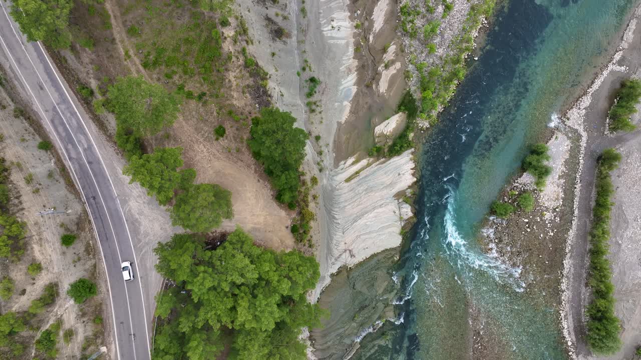 울창 한 계곡 을 가로지르는 휘어지는 강 과 도로 의 공중 풍경